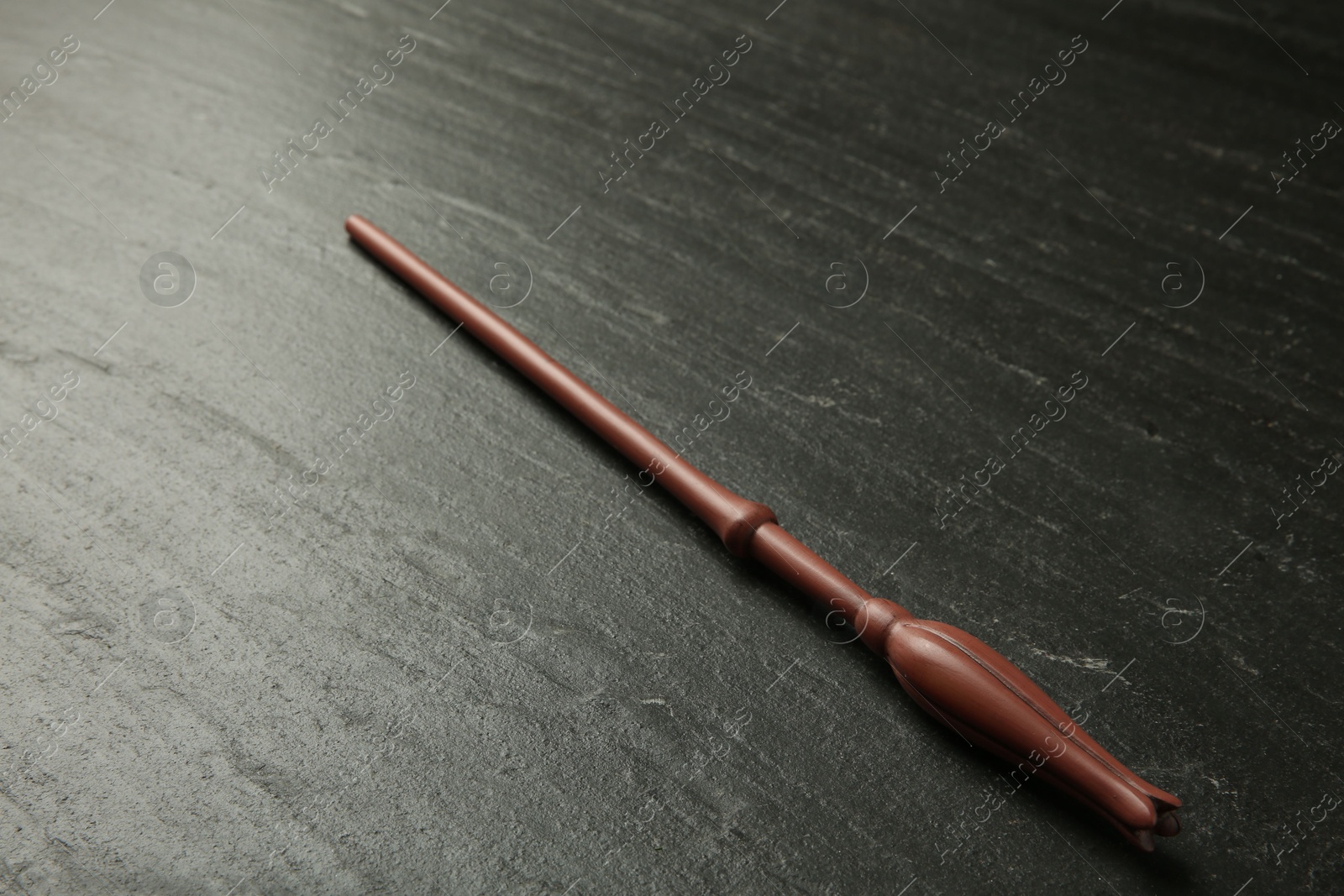 Photo of One old magic wand on black table, closeup