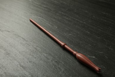 Photo of One old magic wand on black table, closeup