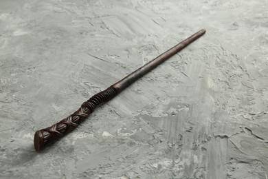 Photo of One old magic wand on grey textured table, closeup