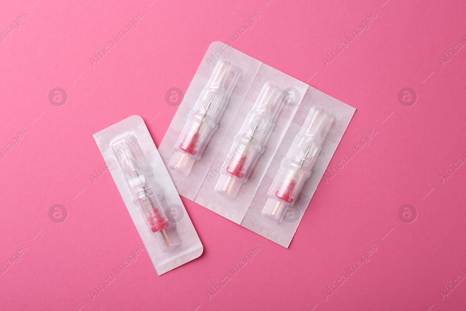 Photo of Disposable cartridge systems for permanent makeup on pink background, top view