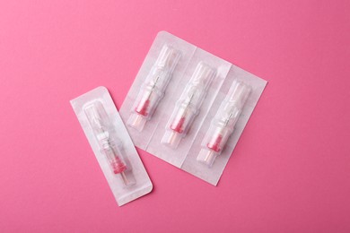 Disposable cartridge systems for permanent makeup on pink background, top view