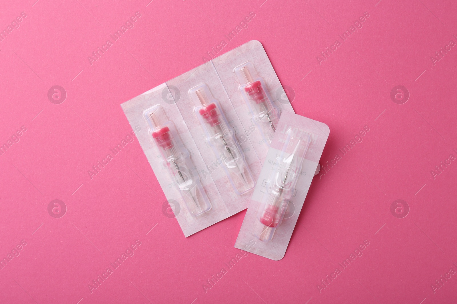 Photo of Disposable cartridge systems for permanent makeup on pink background, top view