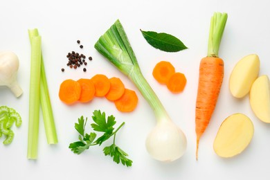 Photo of Pieces of fresh ripe carrots, vegetables and spices on white background, flat lay