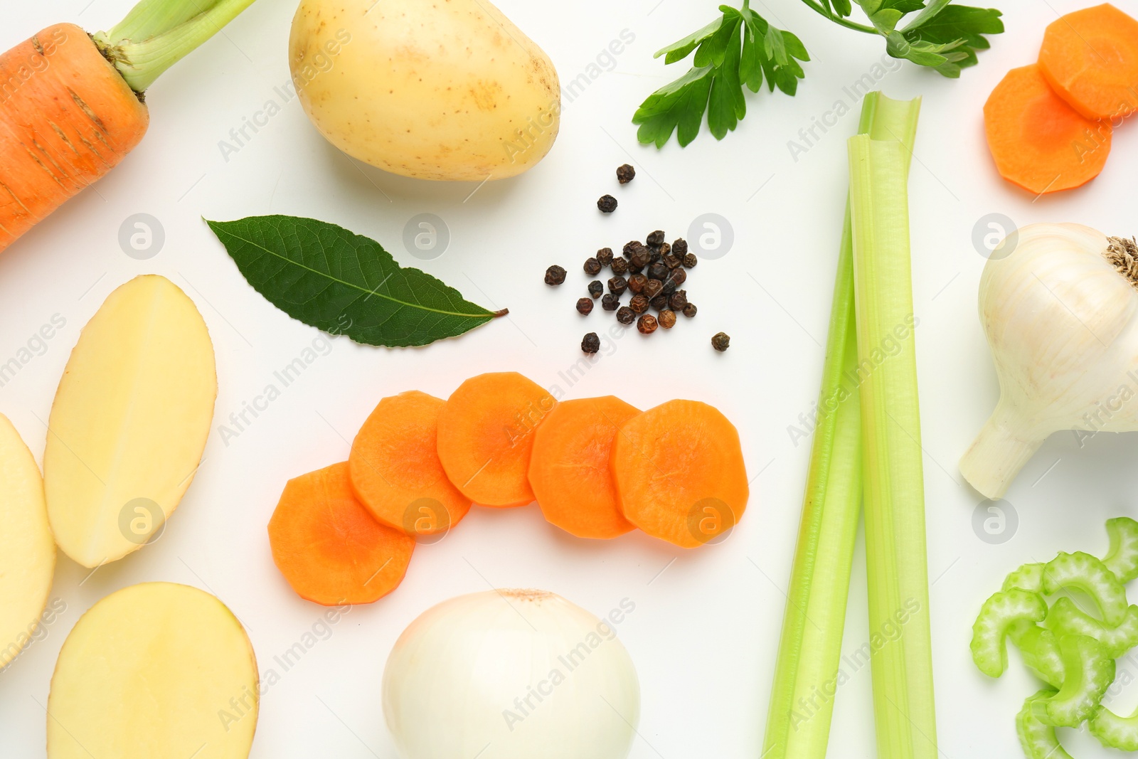 Photo of Pieces of fresh ripe carrots, vegetables and spices on white background, flat lay