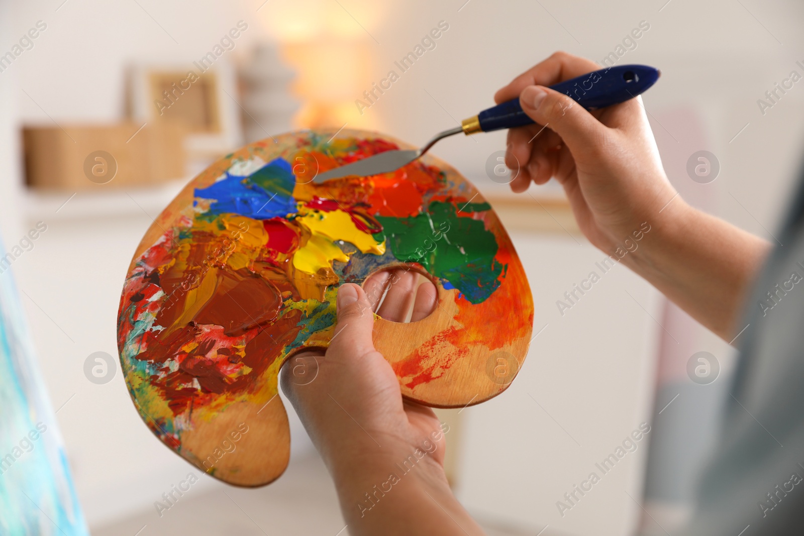 Photo of Woman with knife using palette indoors, closeup