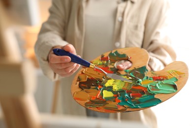 Photo of Woman with knife using palette indoors, closeup