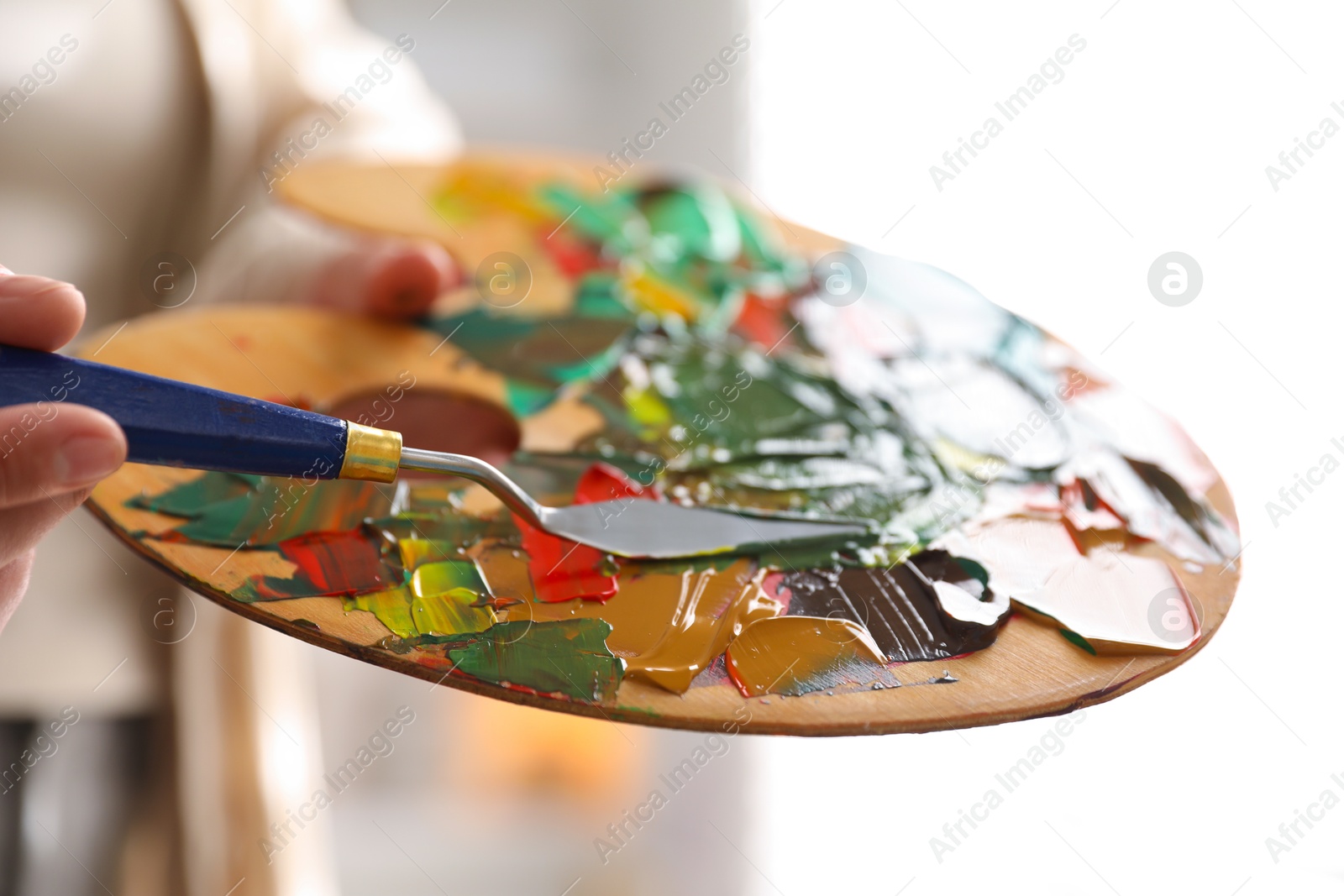 Photo of Woman with knife using palette indoors, closeup