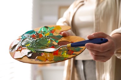 Photo of Woman with knife using palette indoors, closeup