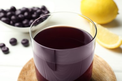 Photo of Delicious acai juice in glass on white table, closeup