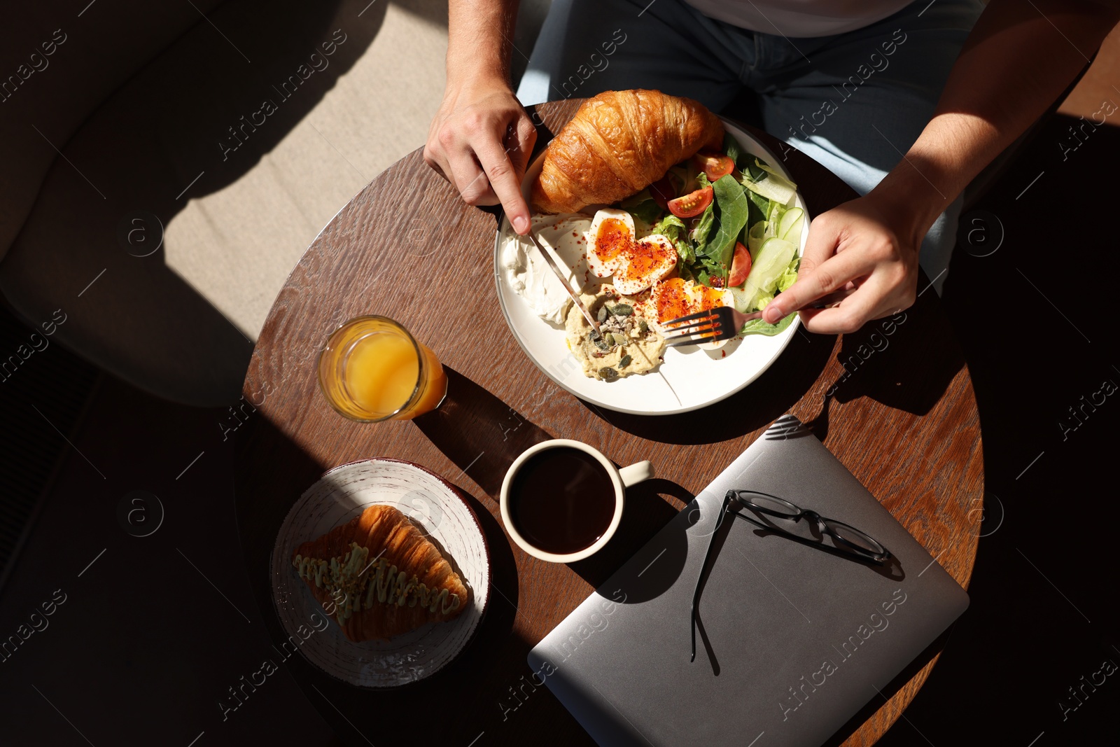 Photo of Man having tasty breakfast in cafe, top view