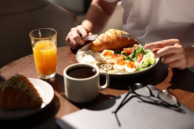 Photo of Man having tasty breakfast in cafe, closeup