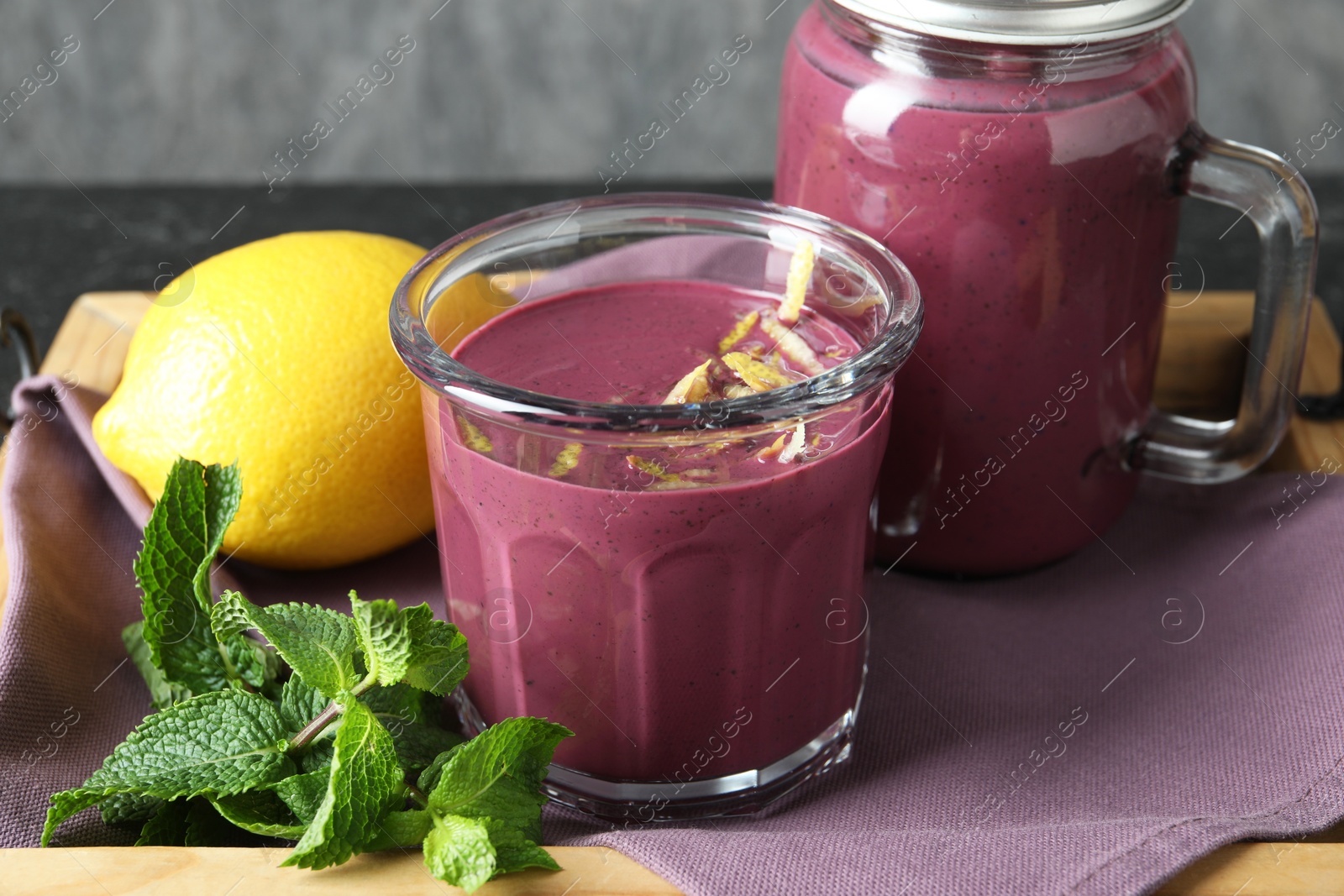 Photo of Tasty fresh acai juice with mint and lemon on table, closeup