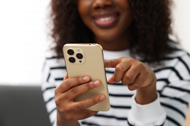 Beautiful woman using mobile phone at home, closeup