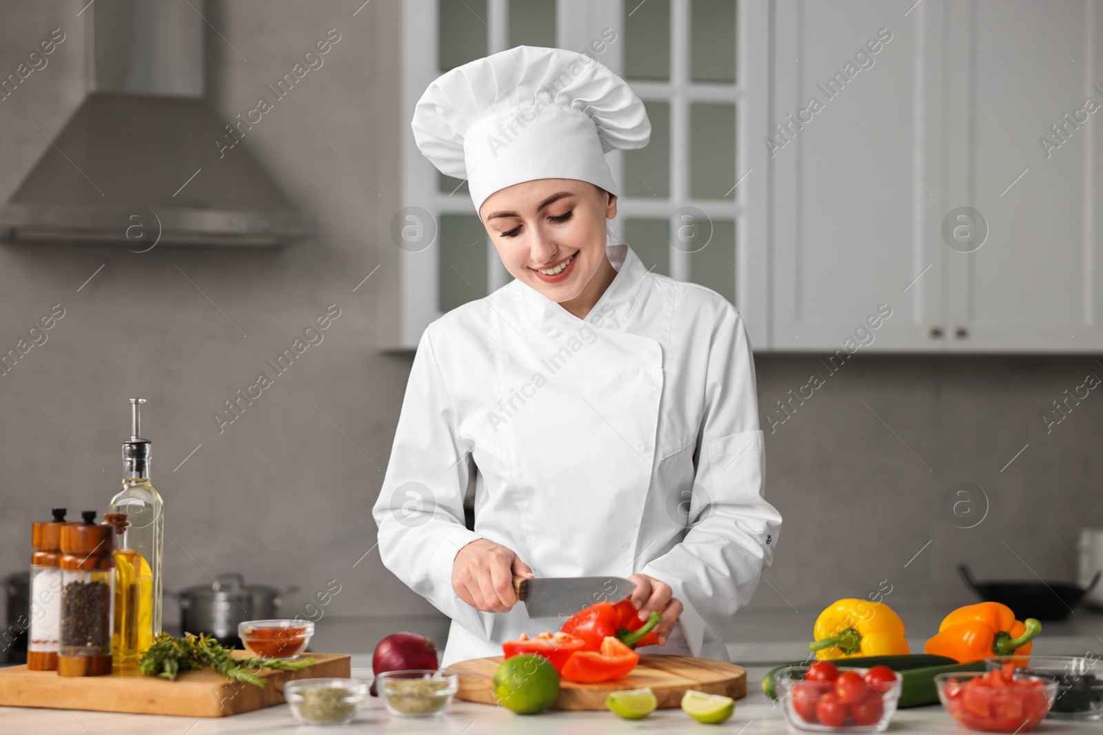 Photo of Professional chef cutting pepper at table in kitchen