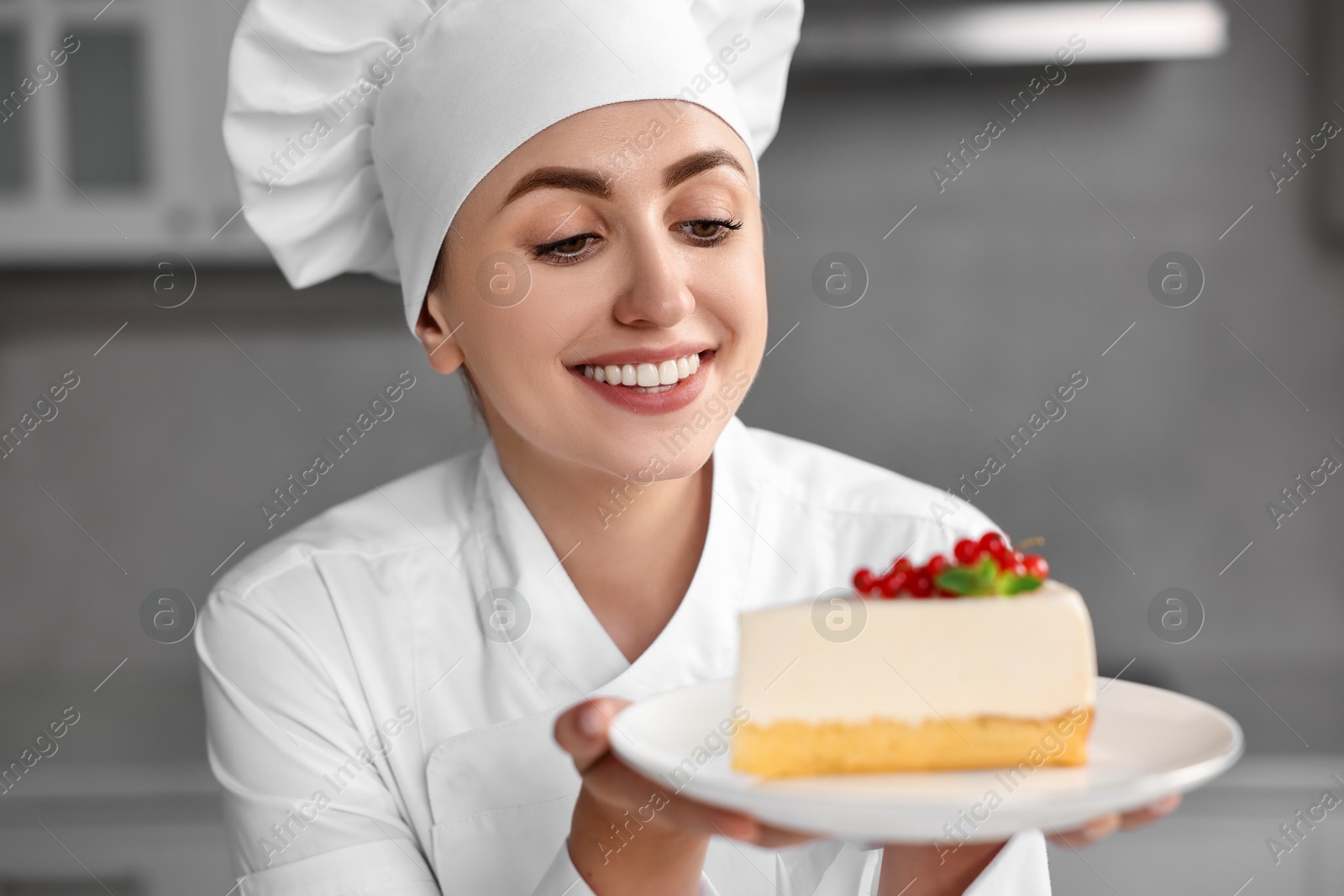 Photo of Professional chef with piece of delicious cheesecake in kitchen