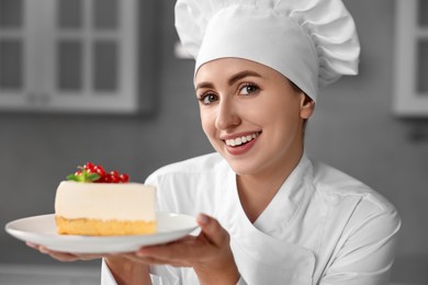 Photo of Professional chef with piece of delicious cheesecake in kitchen