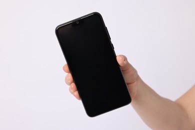 Photo of Woman holding smartphone with blank screen on white background, closeup