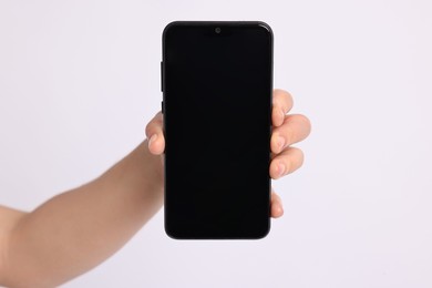 Photo of Woman holding smartphone with blank screen on white background, closeup