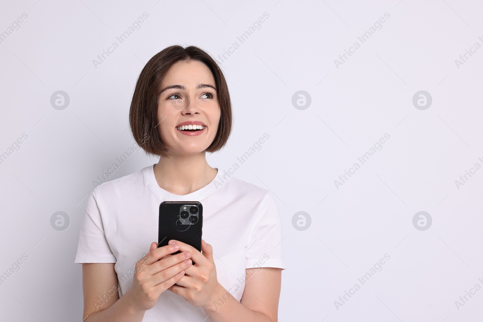 Photo of Happy woman with smartphone on white background. Space for text