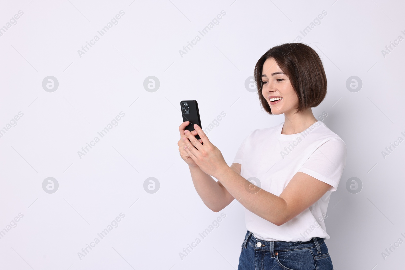 Photo of Happy woman with smartphone on white background. Space for text