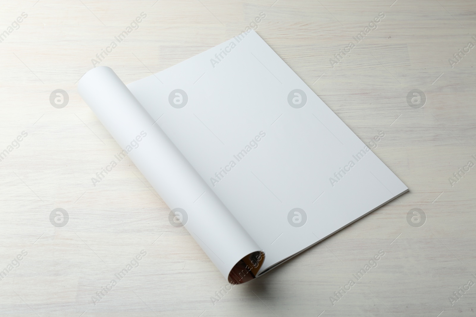 Photo of Open magazine with blank page on light wooden table. Mockup for design