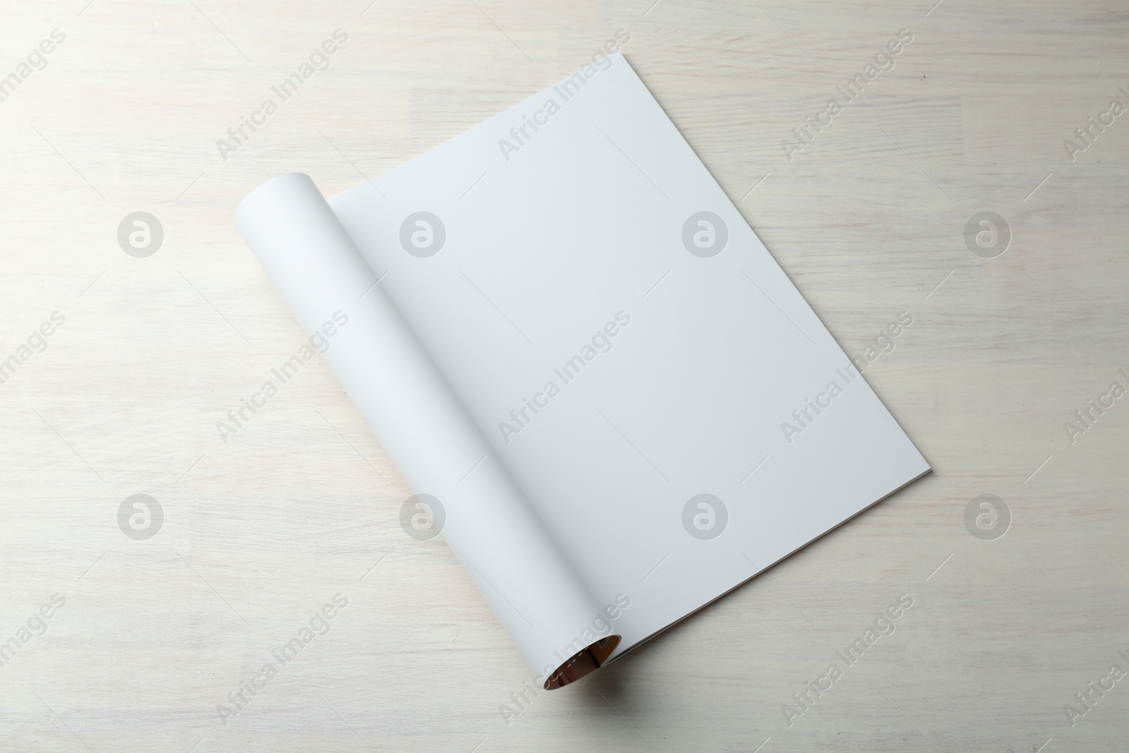 Photo of Open magazine with blank page on light wooden table. Mockup for design