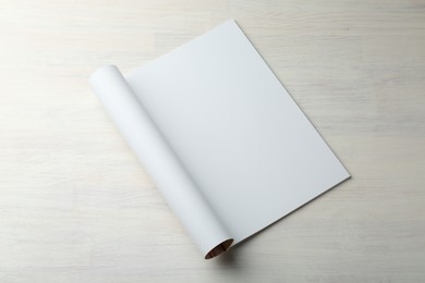 Photo of Open magazine with blank page on light wooden table. Mockup for design