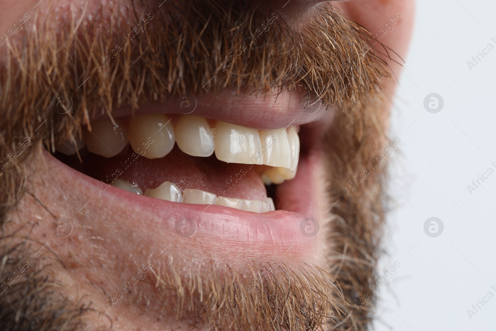 Photo of Smiling man with healthy clean teeth on white background, closeup