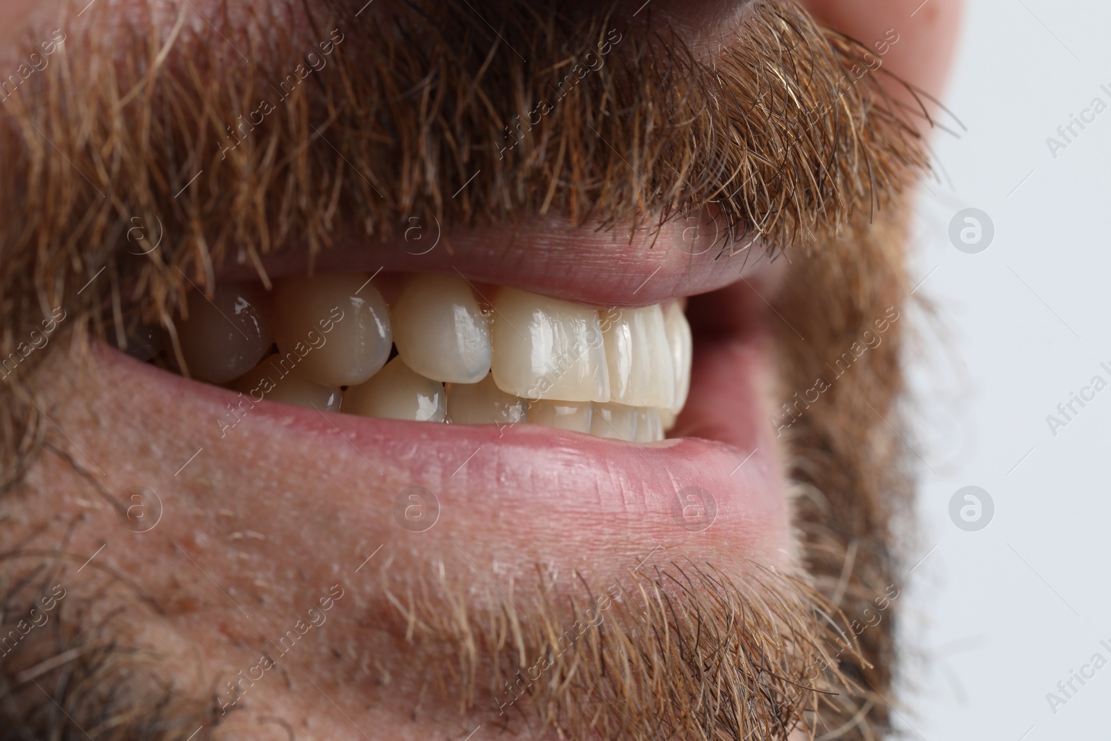 Photo of Smiling man with healthy clean teeth on white background, closeup