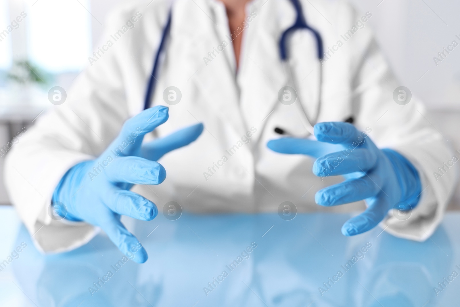 Photo of Doctor holding something at table in clinic, closeup