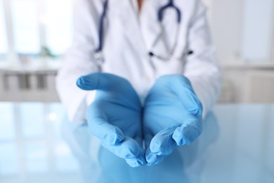 Photo of Doctor holding something at table in clinic, closeup