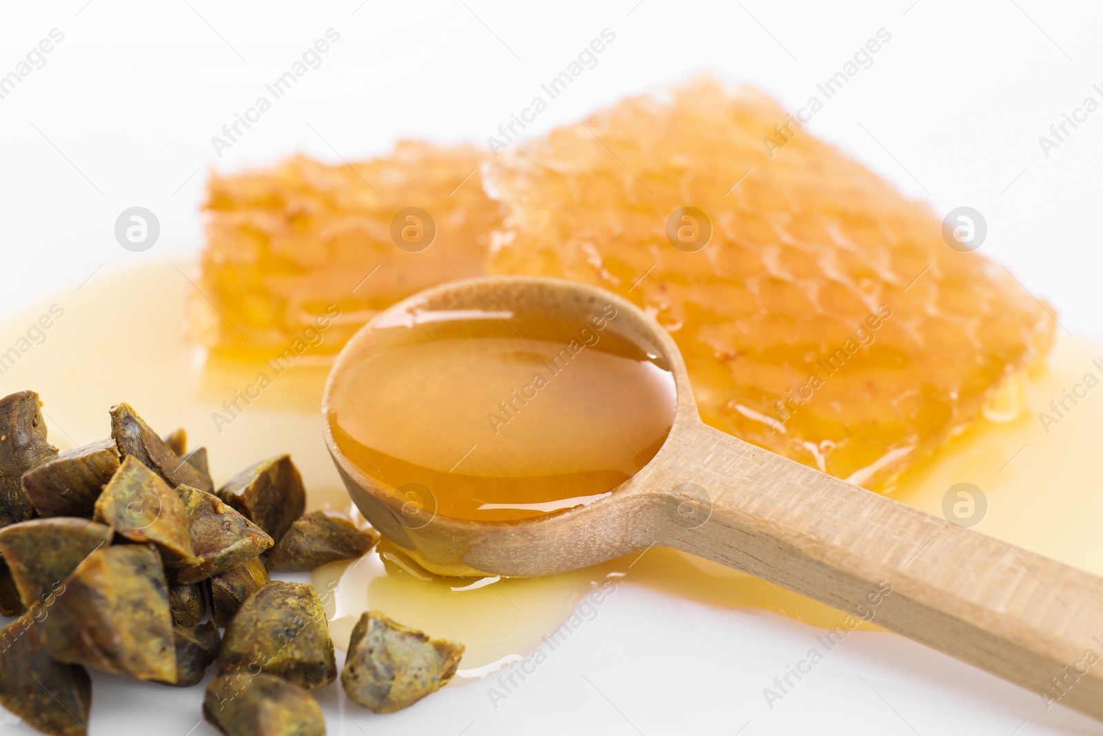 Photo of Sweet honeycombs and propolis granules on white background, closeup