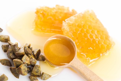 Photo of Sweet honeycombs and propolis granules on white background