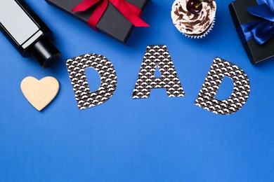 Happy Father's Day. Word Dad made of paper, decorative heart, perfume, gift boxes and cupcake on blue background, flat lay. Space for text