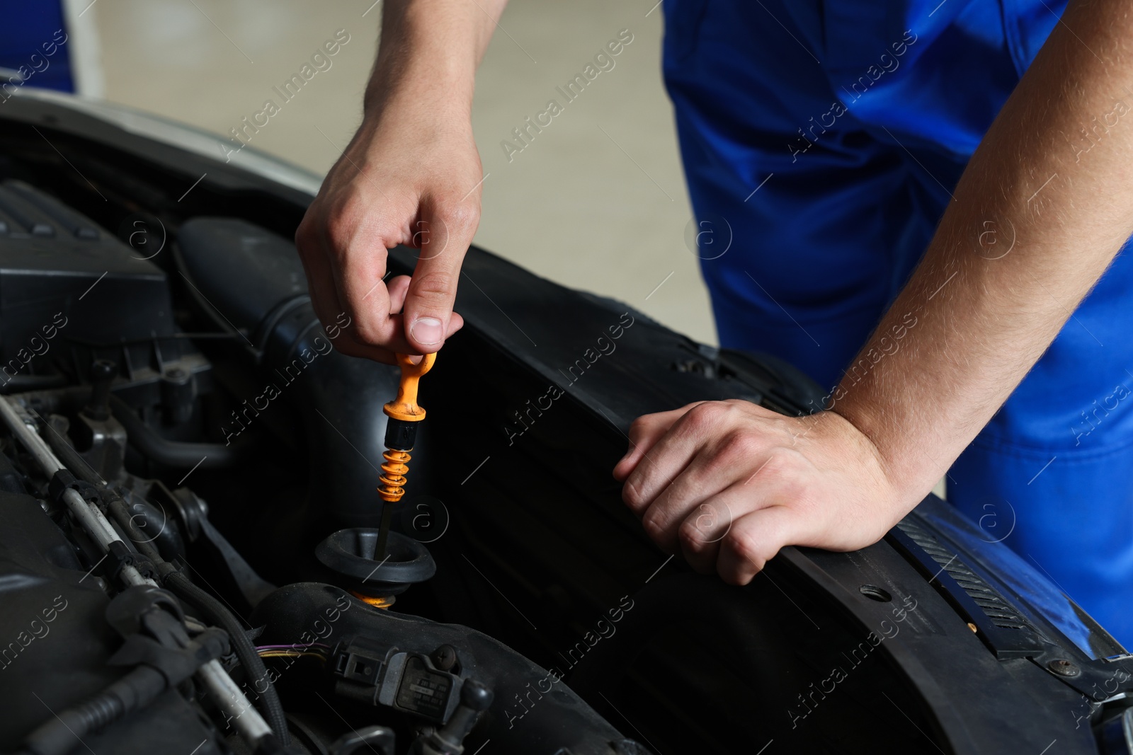 Photo of Auto mechanic fixing car at automobile repair shop, closeup