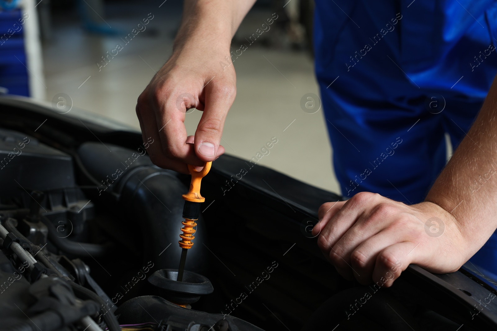 Photo of Auto mechanic fixing car at automobile repair shop, closeup