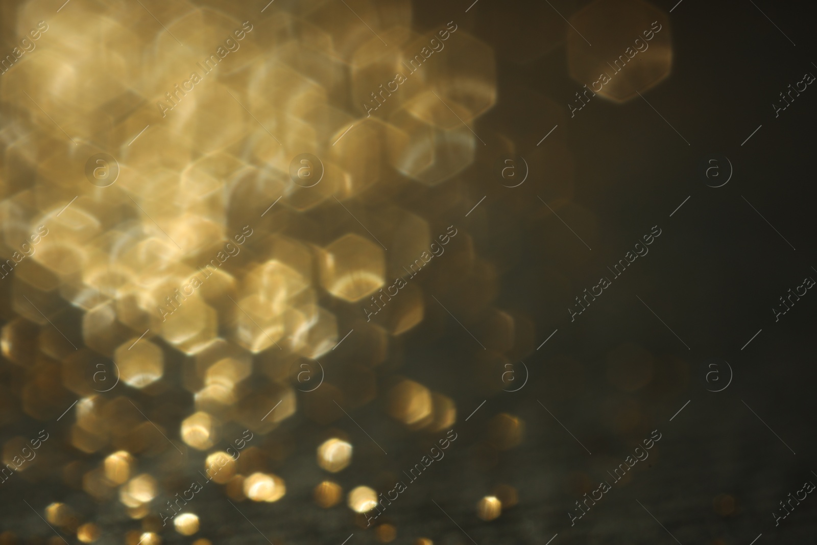 Photo of Beautiful shiny golden glitter on black background, closeup