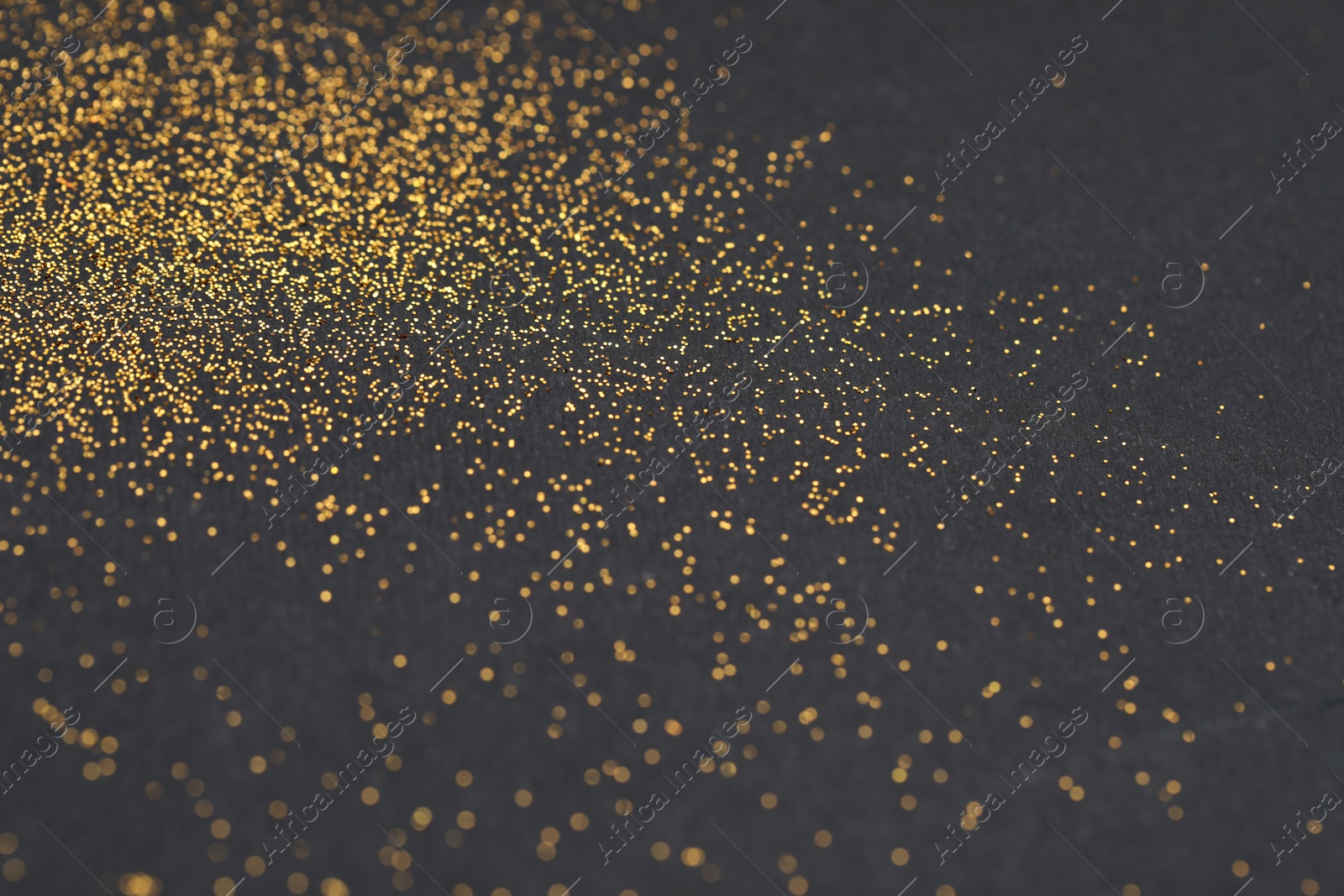 Photo of Beautiful shiny golden glitter on black background, closeup