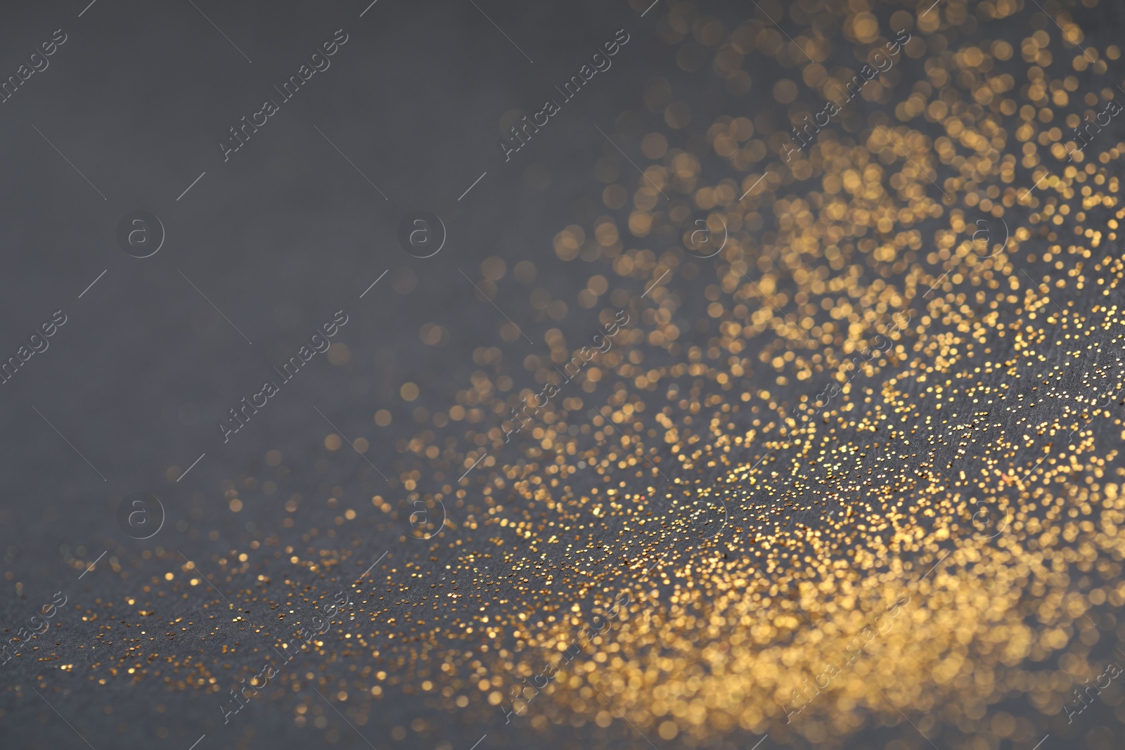 Photo of Beautiful shiny golden glitter on black background, closeup