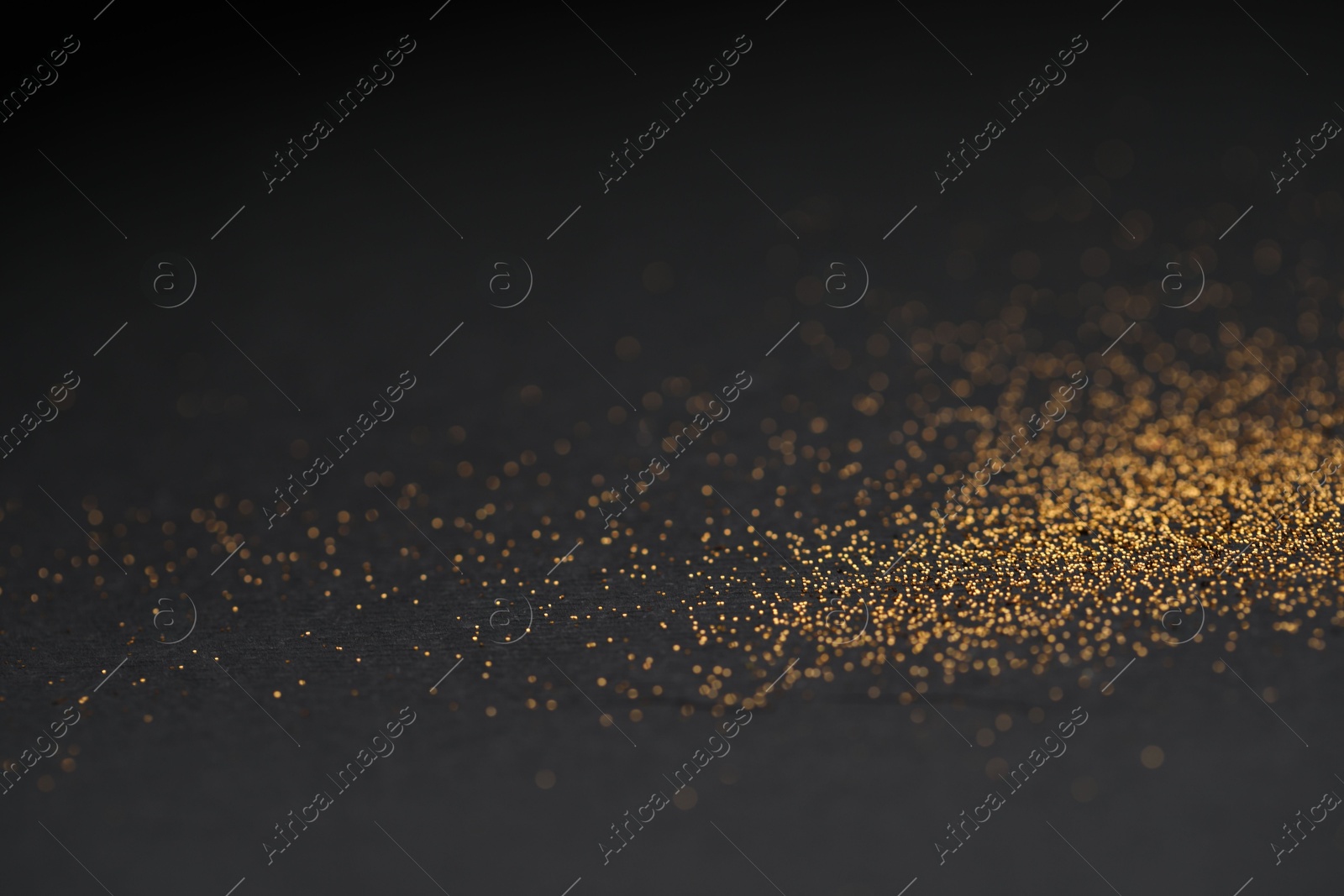 Photo of Beautiful shiny golden glitter on black background, closeup