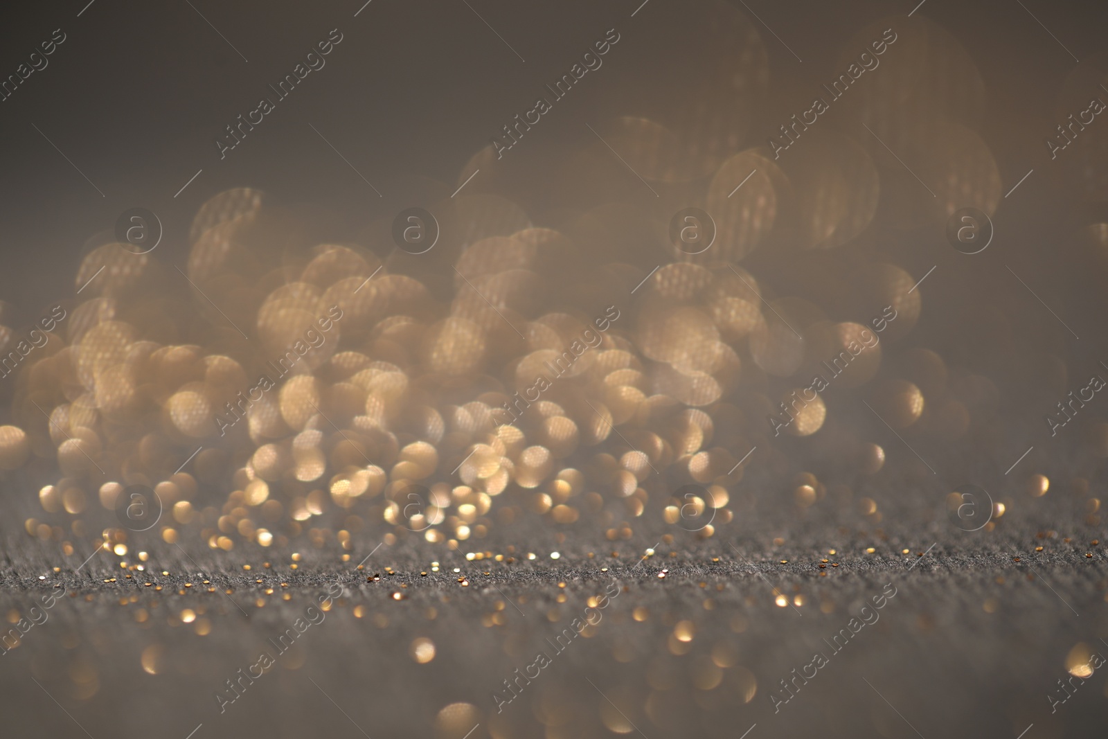 Photo of Beautiful shiny glitter on grey background, closeup