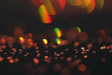 Photo of Beautiful shiny golden glitter on black background, closeup