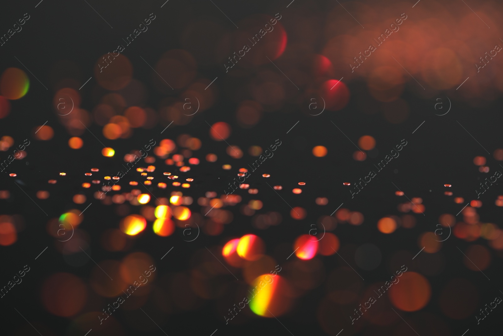 Photo of Beautiful shiny golden glitter on black background, closeup