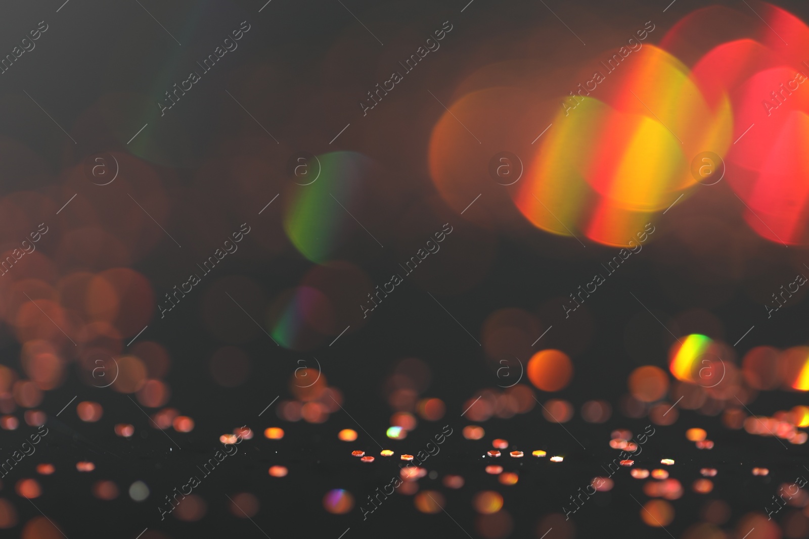 Photo of Beautiful shiny golden glitter on black background, closeup