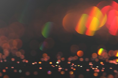 Photo of Beautiful shiny golden glitter on black background, closeup