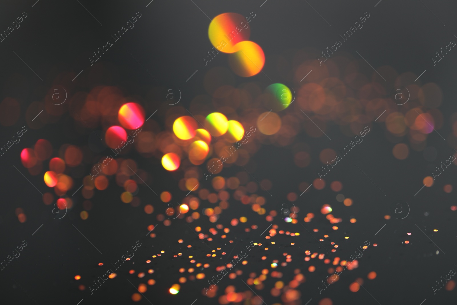 Photo of Beautiful shiny golden glitter on black background, closeup