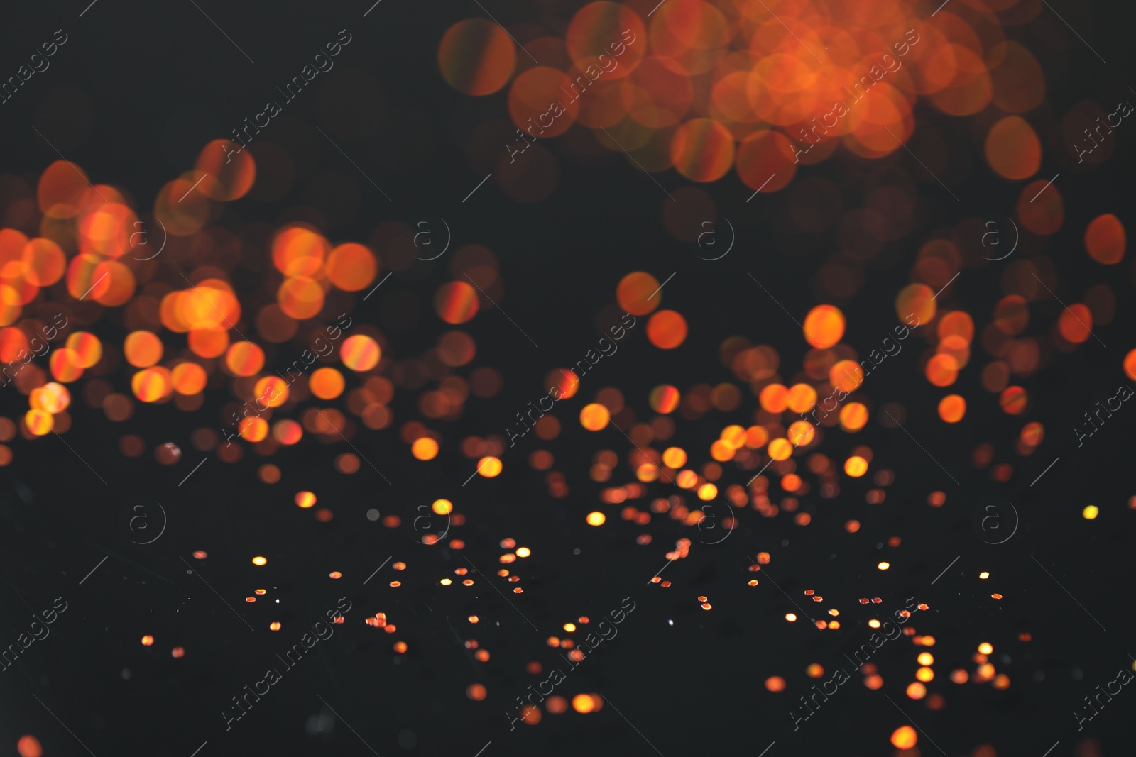 Photo of Beautiful shiny golden glitter on black background, closeup