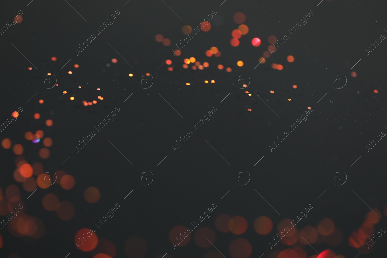 Photo of Beautiful shiny golden glitter on black background, closeup