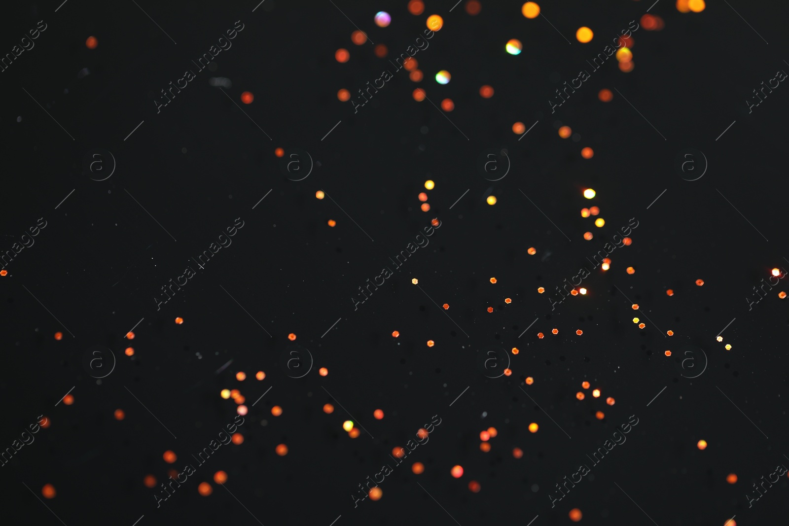 Photo of Beautiful shiny golden glitter on black background, closeup