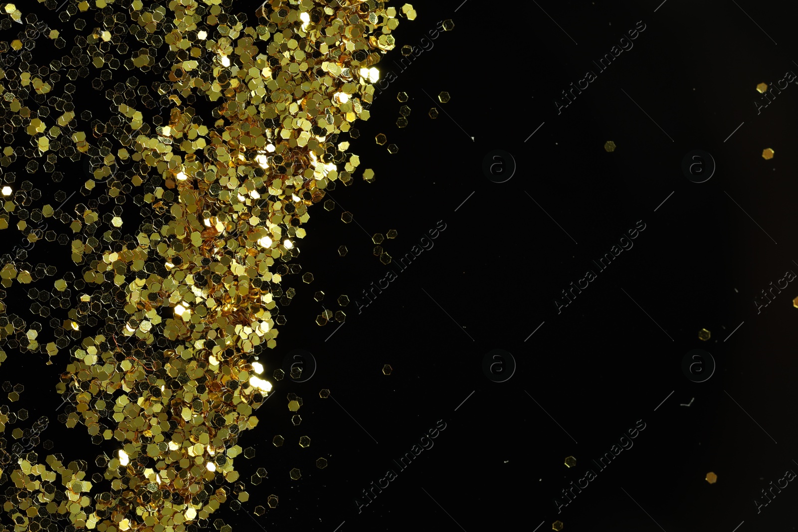 Photo of Beautiful shiny golden glitter on black background, top view